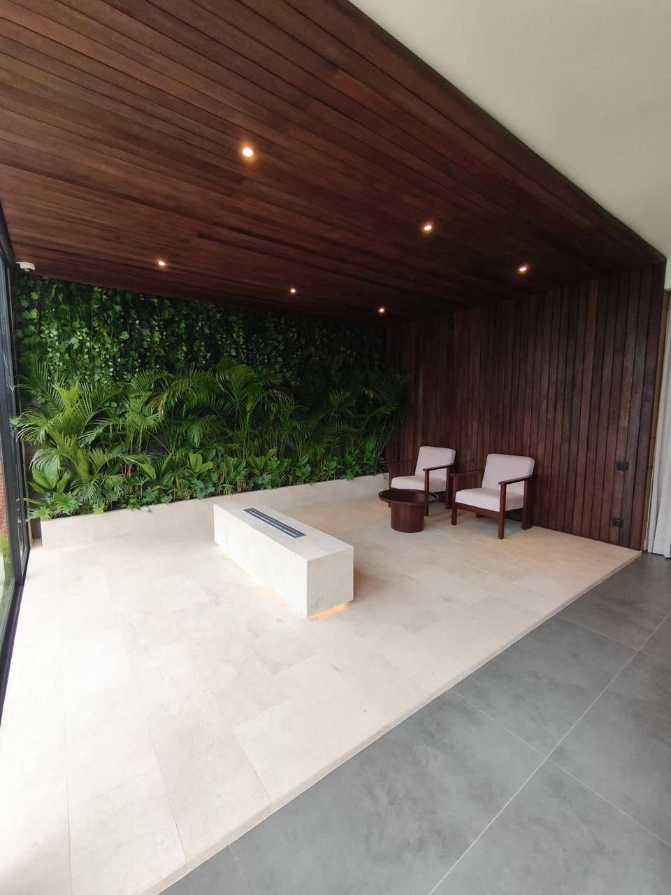 Timber-ceilinged lounge with garden wall